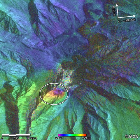 「だいち2号」が観測した御嶽山の噴火(2014年9月27日)前後の比較画像。衛星と地表の距離の変化を色で示したもの。丸内が黄～赤に変化しており、衛星に近づく変化があったと考えられる。